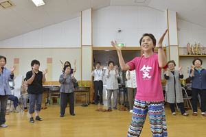 講師の手拍子に合わせて笑ヨガを体験する参加者